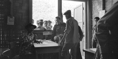 Hmong men gather in a supply office in 1971 Laos